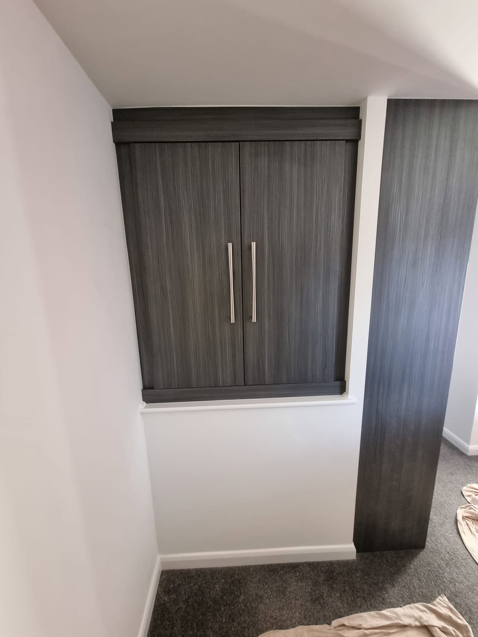 Bespoke alcove wardrobe with grey woodgrain doors closed, fitted into a recess, Edinburgh
