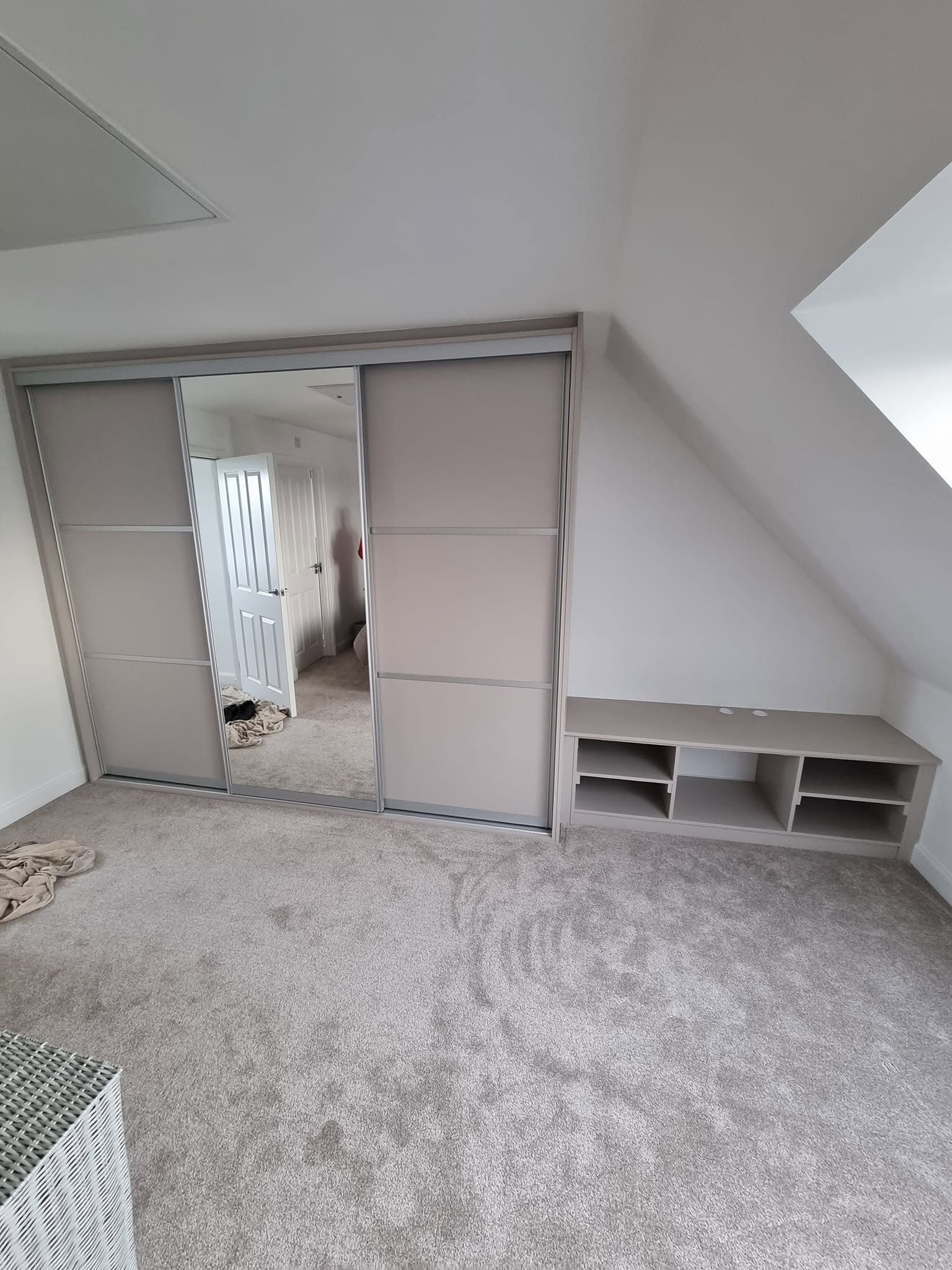 Three-panel sliding wardrobe with mirror doors fitted under a sloped loft ceiling, Edinburgh