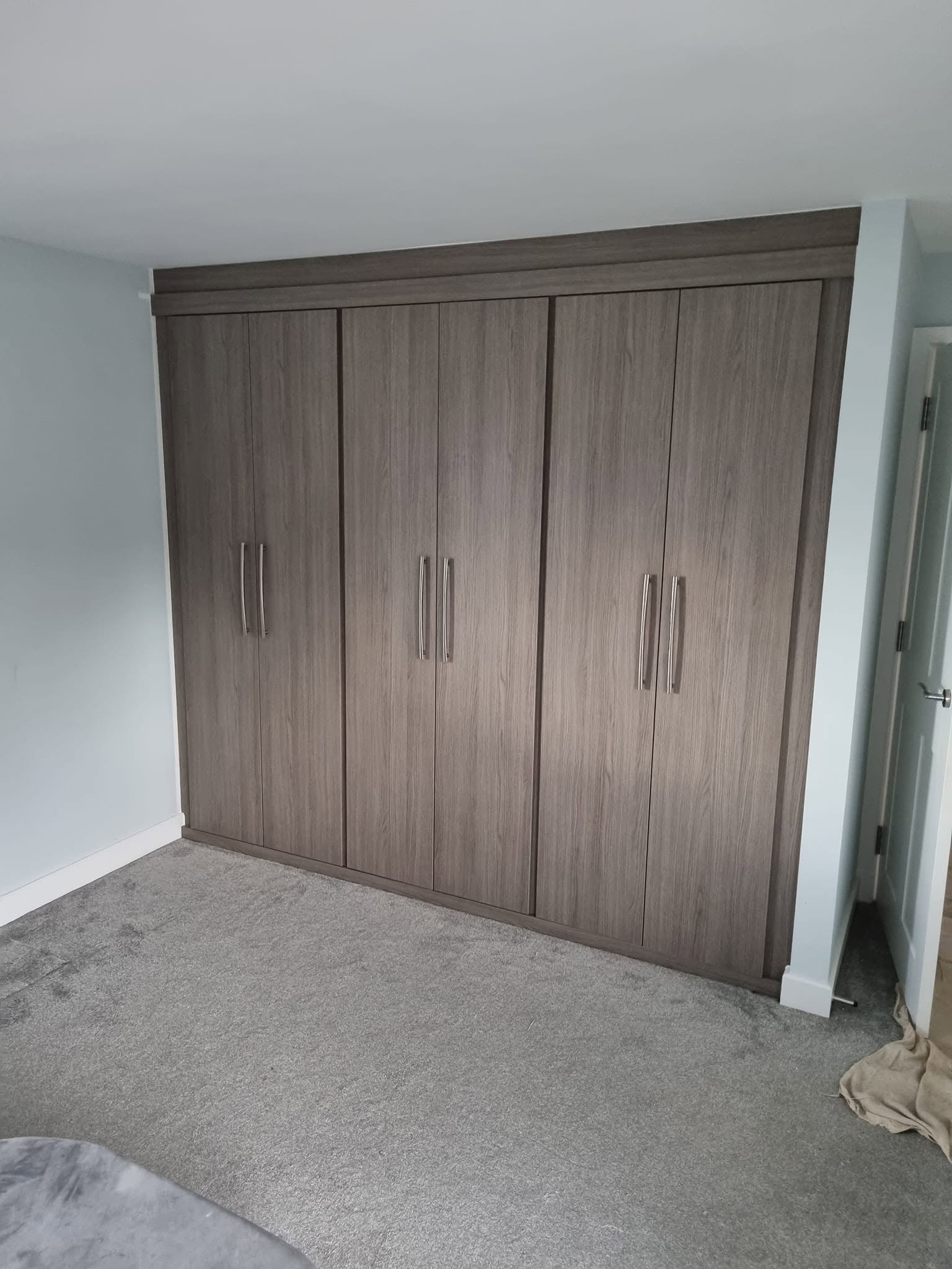 Bespoke six-door fitted wardrobe in grey woodgrain across a bedroom wall, Edinburgh